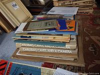 Stack of large souvenir magazines with 'Carlsbad Caves, and a Camera' visible on the top.