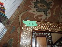 Close up photo of 11x13 wood inlay picture frame with floral design on a carpet background
