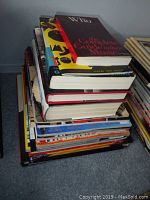 Stack of approximately 15 books about The Who including visible titles with worn edges and covers.