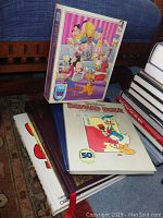 Photos of various Disney character books and unopened puzzle, showing lot contents and condition.