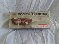 Photo of original product box with Pocket Fisherman branding and image of the reel