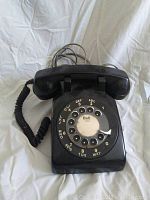 Front view showing rotary dial with Bell logo and handset on top.