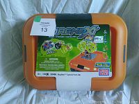 Front and top view of orange plastic tub with label showing MagNext branding and Mega Bloks logo. Tub is unopened and sealed.