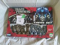Full boxed view of the Transformers chess set showing packaging and chess pieces inside plastic window.