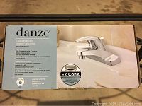 Box showing Danze branding, model, and features including fit for 3-hole sinks with 4 inch centers, EZ ConX installation, and chrome finish