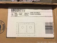 Label on the cardboard box showing specifications of the sink: 3 faucet holes, 3.5 inch waste hole, sink double, dimensions 20.5x31.25 inches.