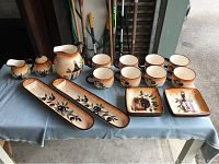 Full display of ceramic set including juice jug, mugs, plates, dip plates, milk and sugar cups