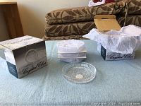Eight glass coasters split into two sets of four, each in branded Crystal Clear boxes with protective white tissue paper.