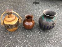 All three vases arranged side by side on asphalt surface showing size and style differences.