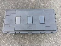 Top down view of closed black plastic Plano storage trunk lid with embossed Plano logo and recessed panels for stacking/stability.