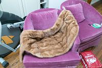 Full view of light brown fur shawl coat draped over a chair, showing fur texture and color.