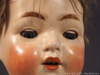 Close-up of the doll's face showing painted features and crackled paint.