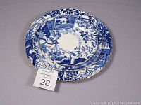Three stacked scalloped bone china plates with blue and white pattern and gold rims, vintage condition.