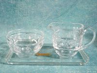 Open sugar bowl and creamer milk jug made of clear lead crystal with etched starburst pattern, resting on a matching rectangular under plate.