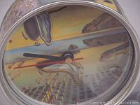 Close-up of clock face showing Salvador Dali artwork and clock hands.