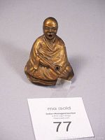 Front view of the bronze/brass Buddha statue incense burner showing the seated figure with incense hole.