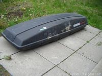 Exterior side view of rooftop cargo box on ground