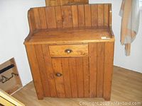 Front view of vintage wooden sideboard showing door, drawer, and raised back panel