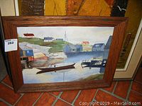 Full view of framed oil painting showing Peggy's Cove scene with boats, houses and rocky shoreline.