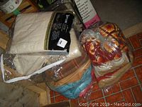 Packaged wool blankets and knitted afghans stacked together