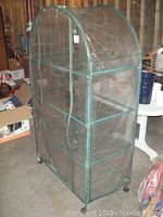 Front and side view of portable greenhouse with transparent plastic cover on metal frame.