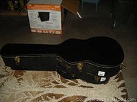 Closed black hard guitar case on floor