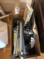 View of two Sony Handycam camcorders, Canon FTb camera, Canon lens, tripod, and camera accessories in cardboard box.