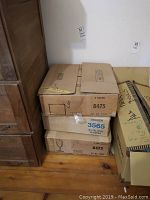 Three cardboard boxes stacked, labeled indicating 3 dozen glasses per box