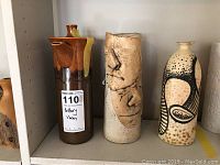 Three pottery vases displayed together on shelf showing shape and colors