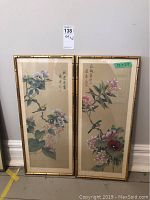 Full view of the two framed silk art panels, showing colorful birds perched on branches of flowers with Asian calligraphy.