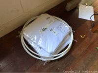 Three IKEA BRYNE bed canopy mosquito nets in original packaging with white frame rings visible on the hardwood floor.