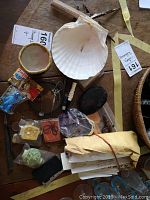 Top view showing an assortment of stamps, shell plates, knife, scissors, and various small items on a wooden surface.