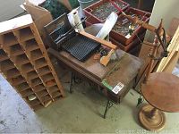 Vintage Singer sewing machine on wooden treadle table with wood cubby organizer adjacent.