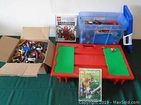 Full view of LEGO pieces in box, play table, and Ninjago books.