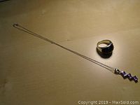 Full view of the sterling silver ring with large dark faceted stone and the sterling silver necklace with pendant showing four dark square stones