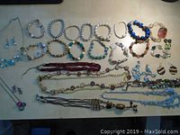 Overview of assorted jewelry including necklaces, bracelets, and earrings laid flat on a surface