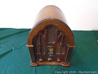 Front view of vintage GE cathedral style radio showing wooden cabinet and speaker grille.