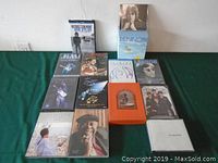 Overview photo of classic rock and reggae music DVDs and CDs arranged on a green cloth
