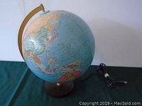 Full view of the 12-inch globe on wooden base with attached electrical cord and yellow support arm