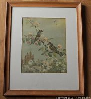 Framed bird print showing two birds on a branch with flowers and a small house in the background.