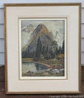 Framed antique oil painting showing a mountain landscape with a lake and red canoe in the foreground.