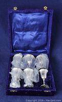 Six silver plate goblets in blue crushed velvet case, some wrapped in protective plastic.