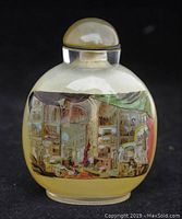 Front view of the glass snuff bottle showing detailed interior painting of a room interior with shelves, musical instruments, and draped curtains
