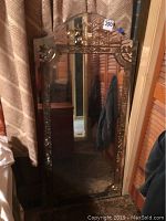 Full view of the vintage wall mirror showing rectangular shape with arched top and detailed frame design