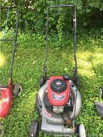 Photo of overall Honda Black Max lawn mower showing metal mower deck, black handle, and wheels on grass surface.