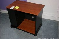 Front view of the TV stand showing wood-finish top and shelves with black sides.
