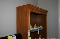 Front side view of the wooden bookshelf showing decorative miniatures on middle shelf.