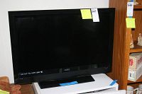 Full front view of the black Vizio 32-inch HDTV showing screen, bezel, and stand.