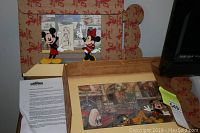 Two Disney animation cel prints displayed in and near original themed cardboard frames, with Mickey and Minnie Mouse.