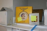 Yellow box containing the M.J. Hummel First Edition 1975 Anniversary Plate in Bisque Relief with original Goebel markings, showing front of box and label.